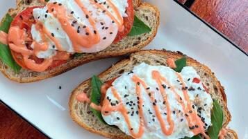 Two open-faced sandwiches on a white plate.
