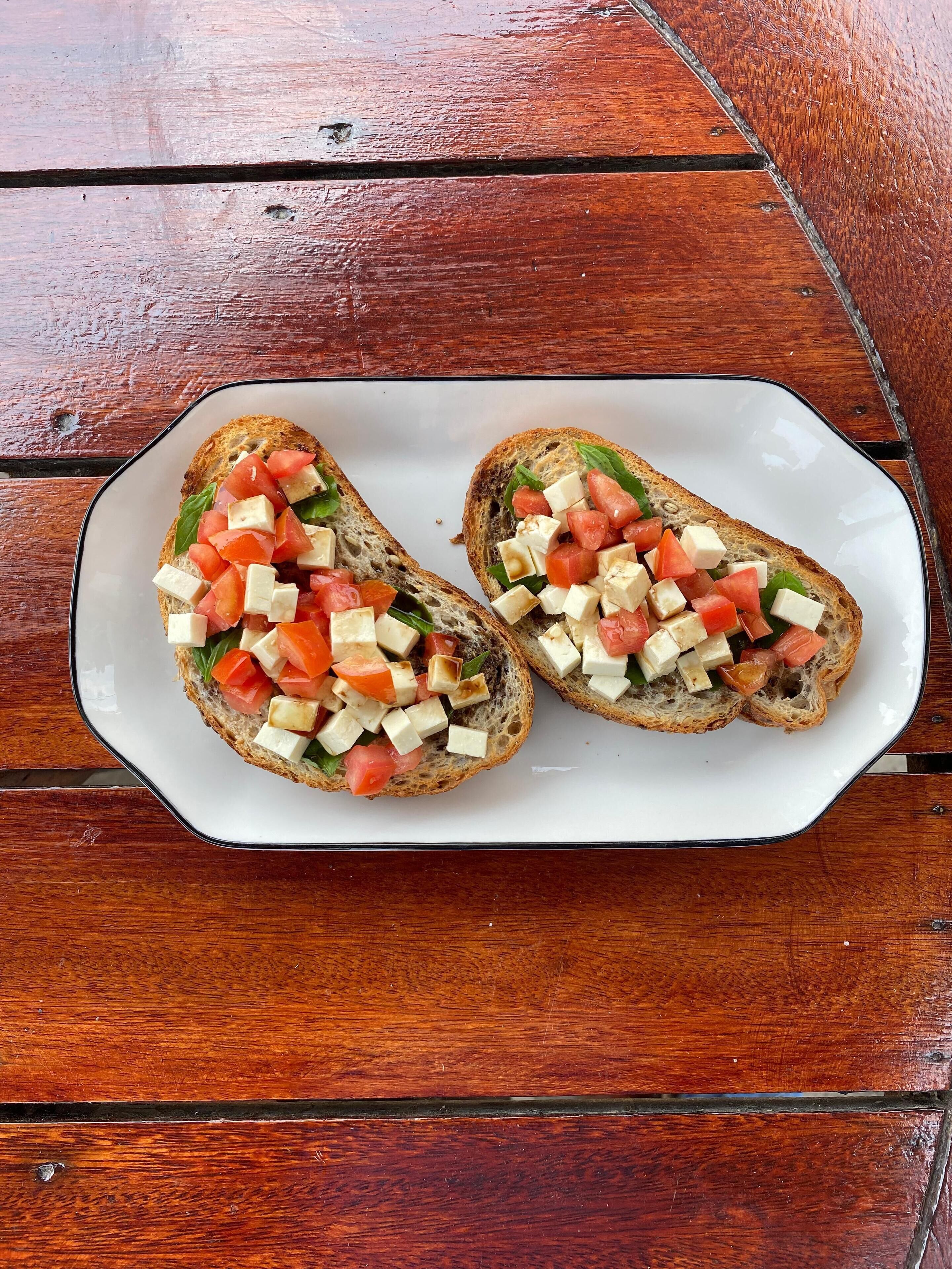 Two pieces of bruschetta on a white plate.