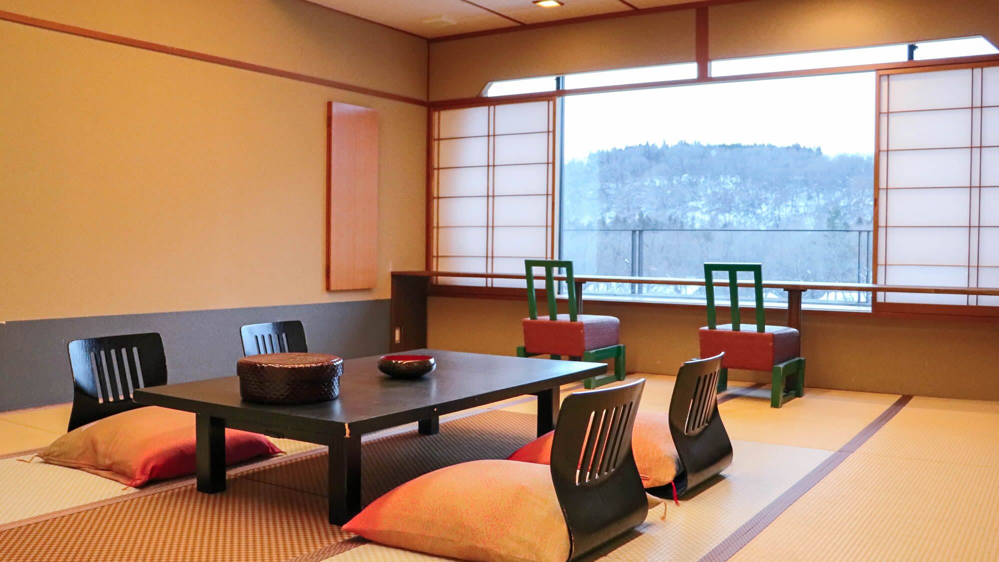 A tatami mat room with a low table, chairs, and a view through large windows.