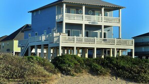 A multi-story beachfront building with balconies, a staircase, and a sign reading 'Amazing Grace.' - Amazing Grace: 7  BR, 5  BA House in Port Bolivar, Sleeps 25 (Port Bolivar)