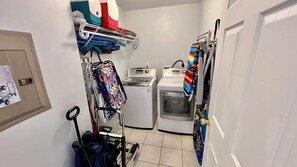 A laundry room with a washing machine, dryer, and a drying rack.