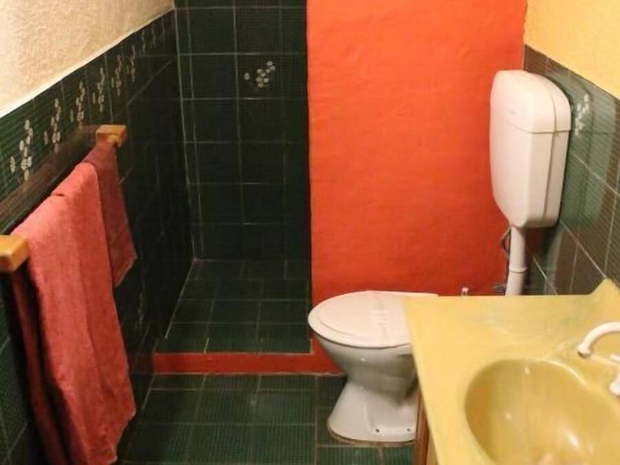 A bathroom with a toilet, sink, and shower area.