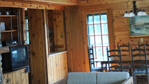 A wooden cabin interior with a loft bedroom, a sofa, and a dining area. - Private beautiful setting, Lyme's best kept secret, Swim, Boat, Fish, Hike (Old Lyme)