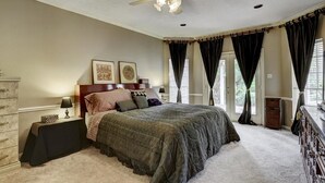 A bedroom with a bed, a nightstand, a dresser, a ceiling fan, and a window with curtains. - Luxury Spectacular House in TX (Sugar Land)