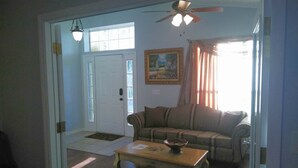 Ein Wohnzimmer mit einer Couch, einem Couchtisch und einem Deckenventilator.