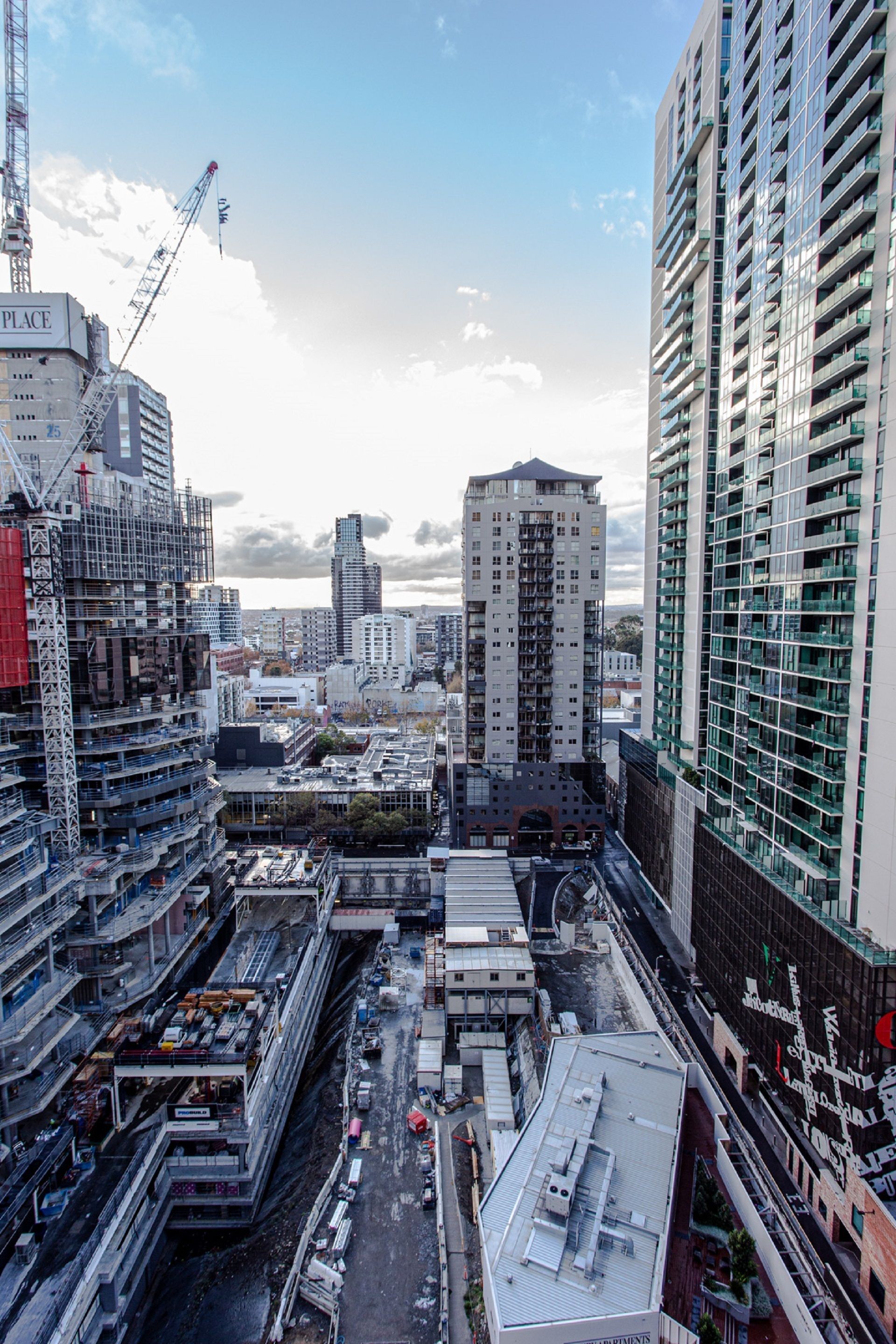 A high-rise building with multiple floors and a construction crane in the foreground.