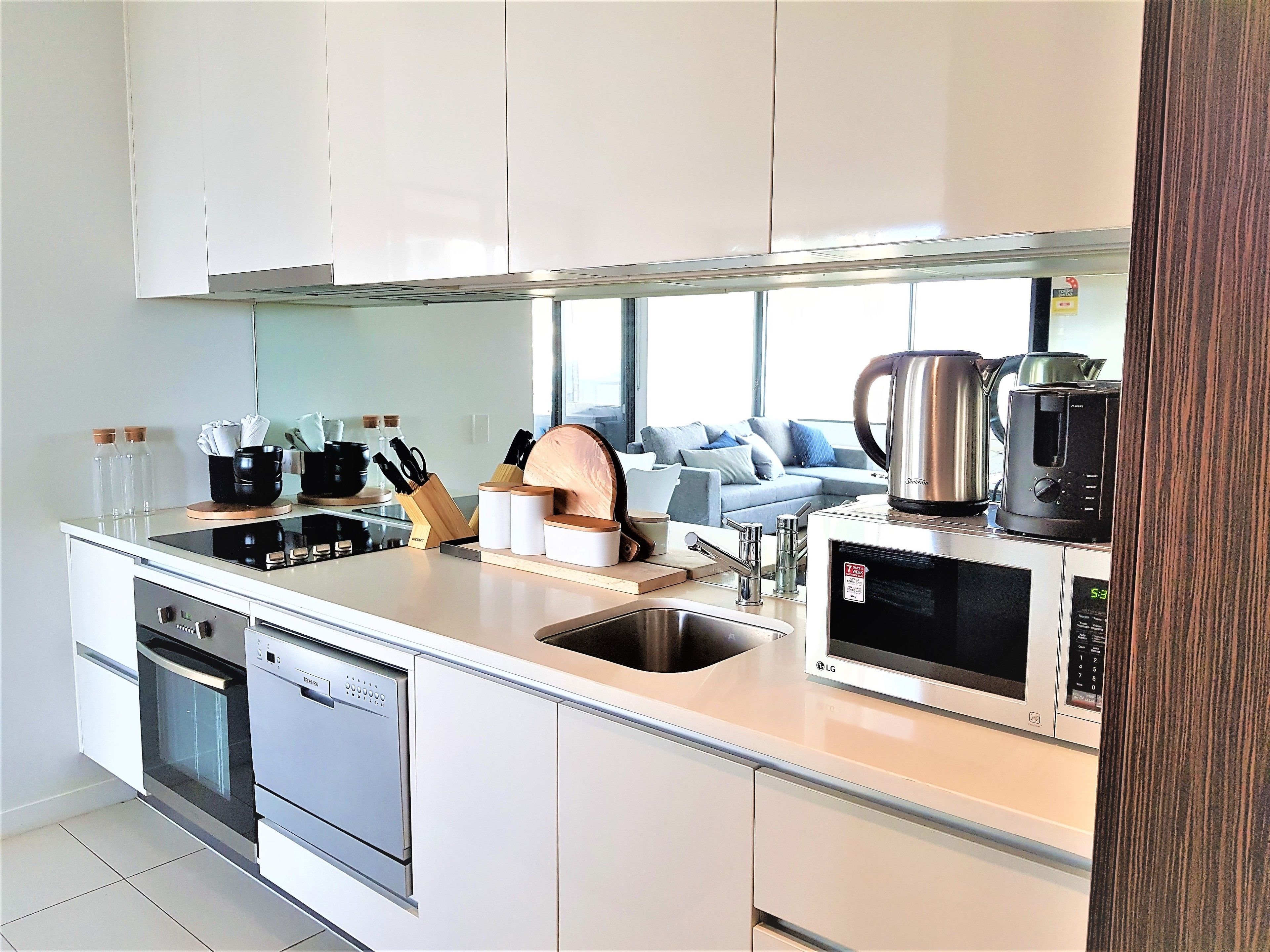 A modern kitchen with an integrated dishwasher, a microwave, and a coffee maker.