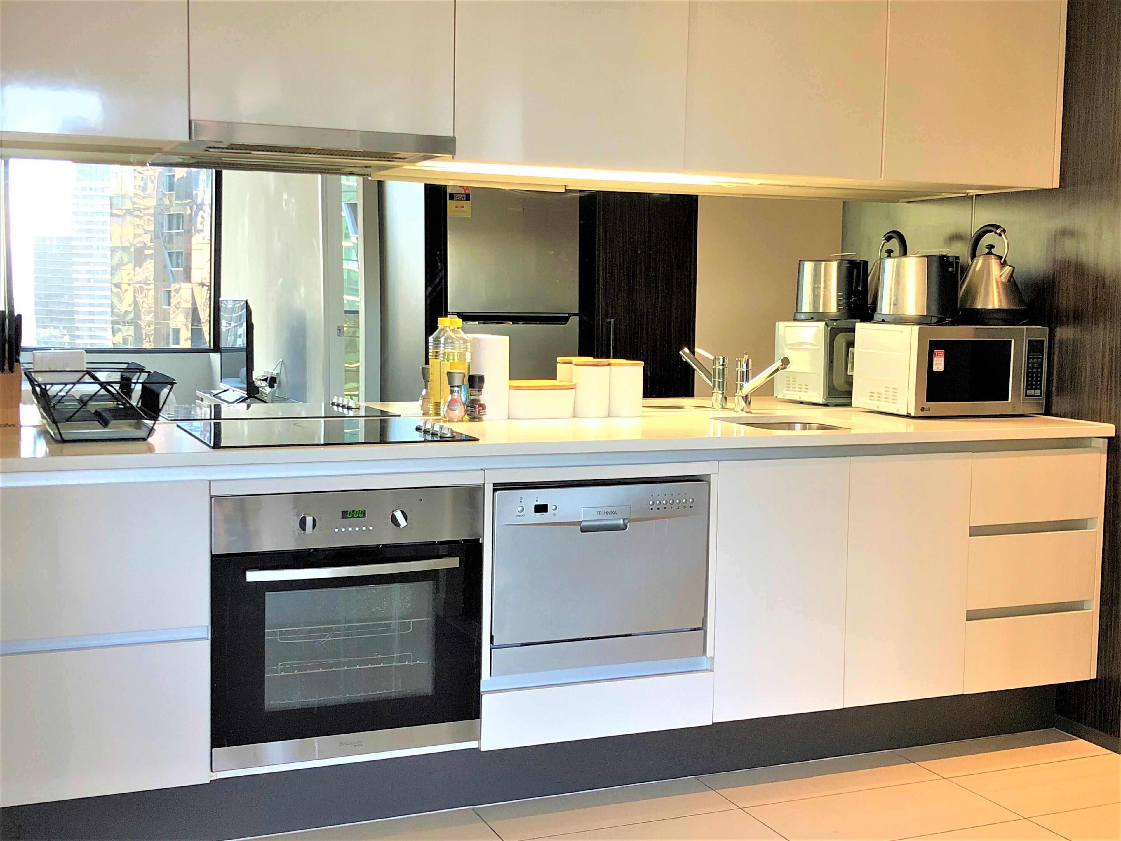 A modern kitchen with stainless steel appliances, a dishwasher, and a microwave.