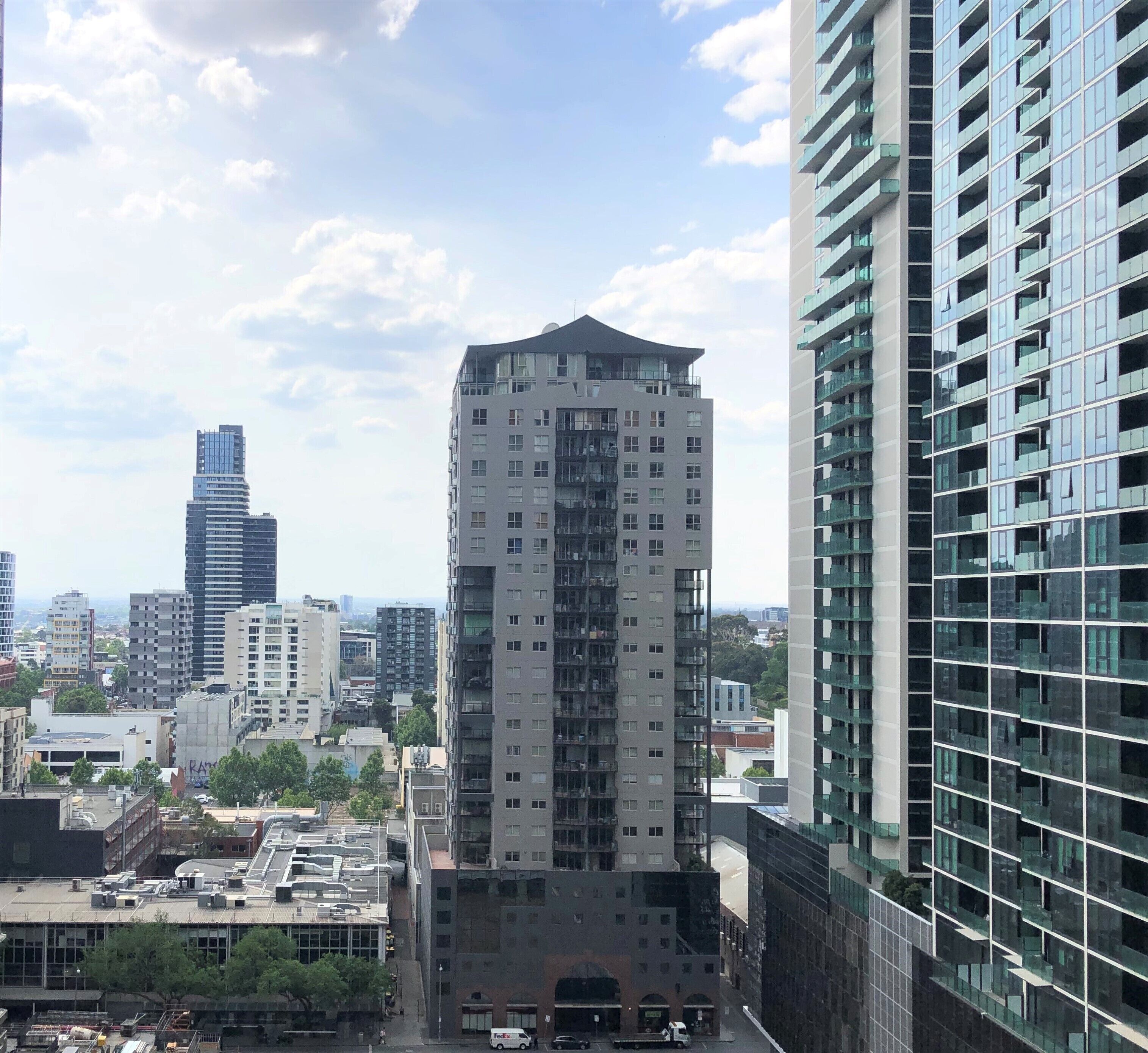 A high-rise building with a modern architectural design, featuring multiple balconies and a glass facade.