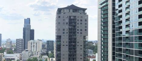 A high-rise building with a modern architectural design, featuring multiple balconies and a glass facade.