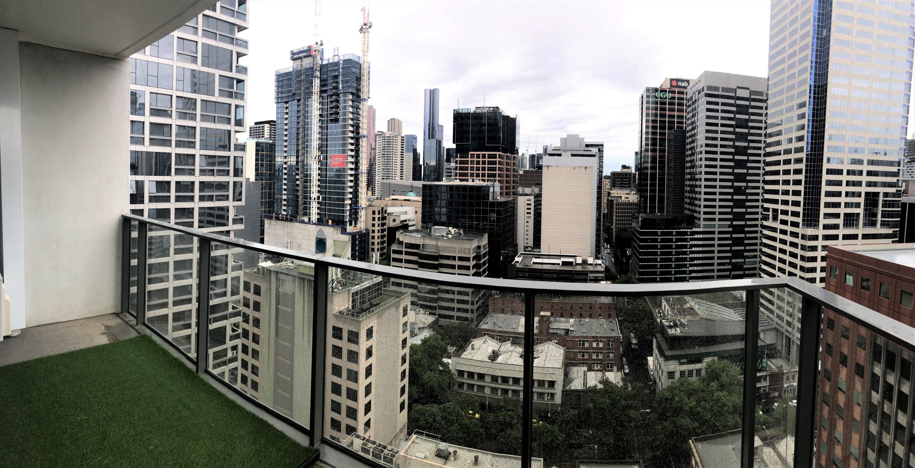 Un immeuble de grande hauteur doté d’un balcon en verre qui offre une vue sur le paysage urbain.