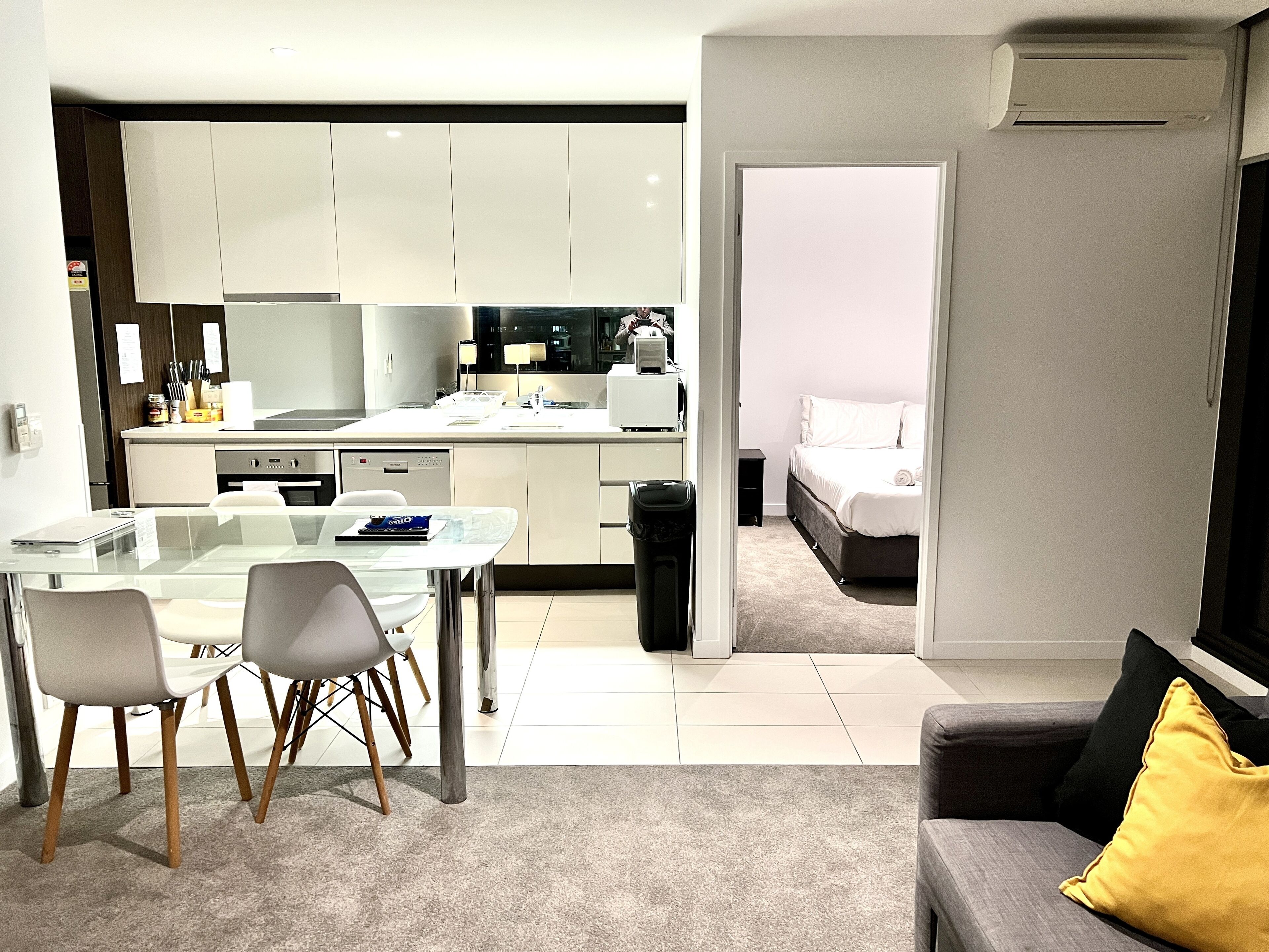 A modern apartment with a kitchen, dining area, and a bedroom.