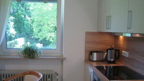 A kitchen with a window, a radiator, a wooden countertop, a toaster, and a sink. - Maisonette apartment with mountain panorama for up to 5 people, 65 sqm, 1 bedroom (Bayerisch Gmain)