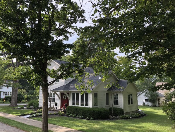 A single-story house with a front porch, a small garden, and a driveway. - Renovated Historic Home! 2 blocks to downtown! (Saugatuck)