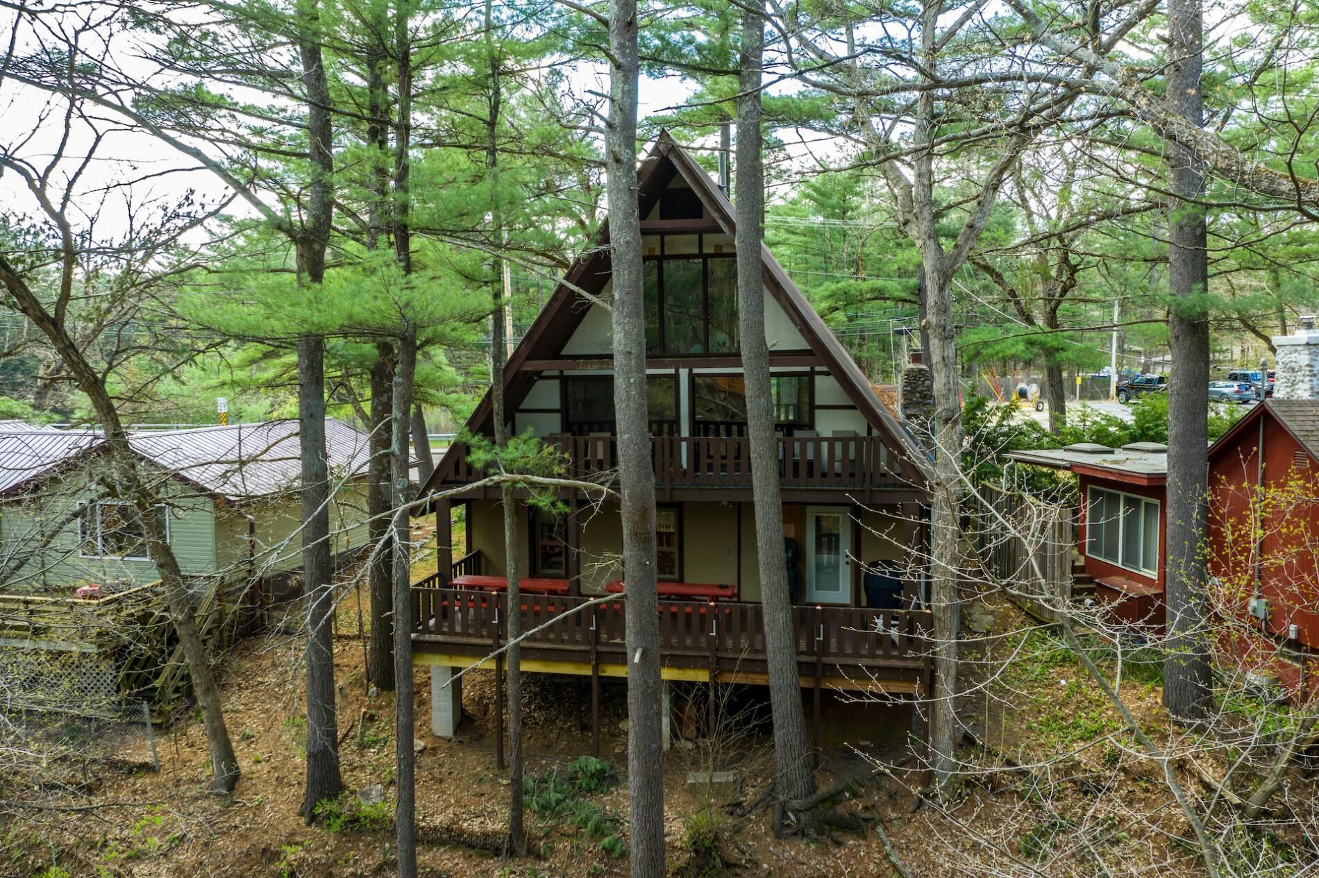 A cabin with a balcony, surrounded by trees.