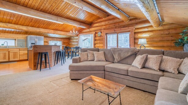 L’intérieur d’une cabane en rondins comprend un salon, une cuisine et un coin repas.
