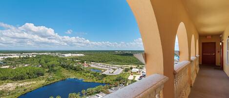 A balcony with a view of a lake, buildings, and greenery.