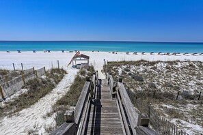A wooden boardwalk leading to a beach with clear blue water and sandy shores. - BEAUTIFUL WATER VIEWS ~ RELAXING COASTAL DECOR! (Destin)