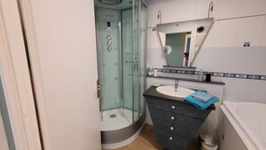 シャワー付き浴槽、ヘアドライヤー、石鹸、トイレットペーパー