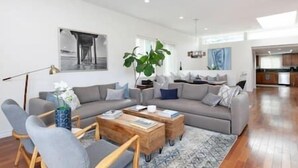 Una sala de estar moderna con un sofá gris, una mesa de centro y una planta grande.