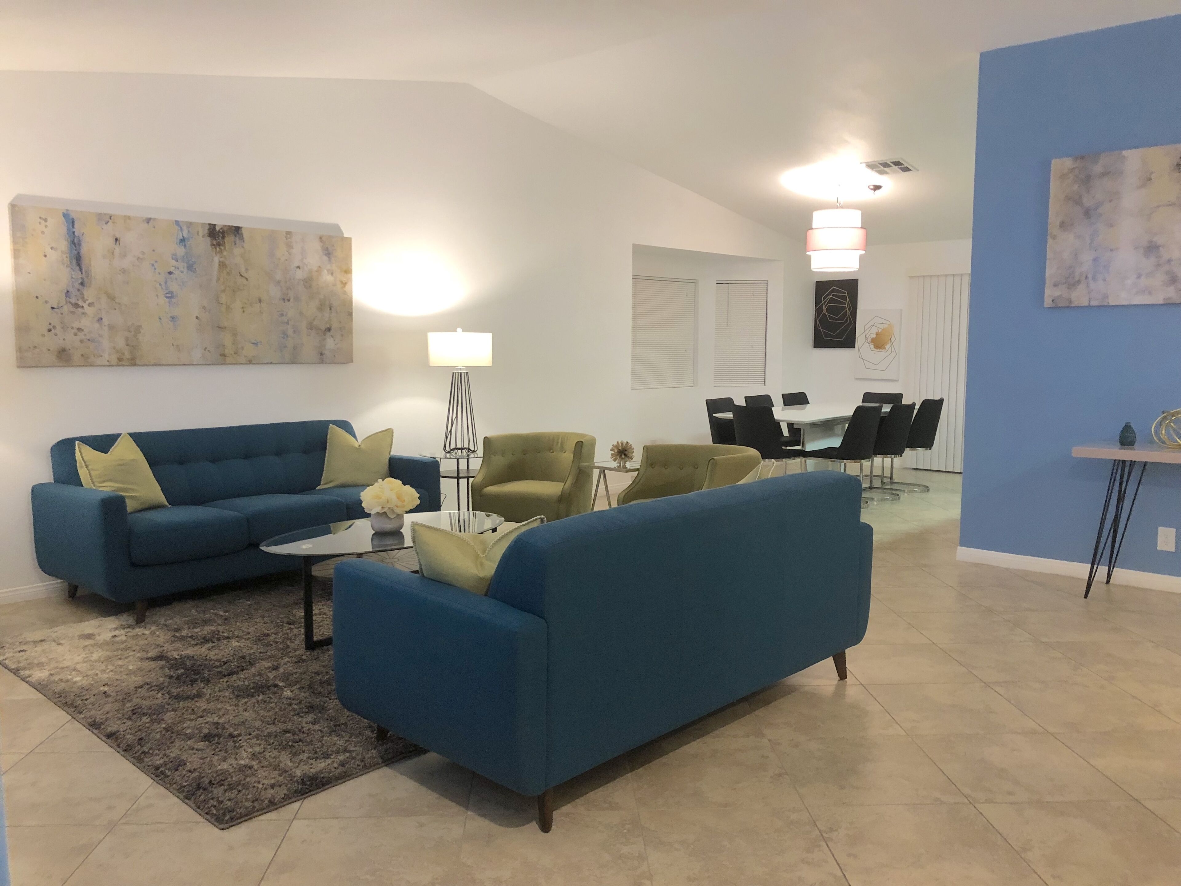 Uma sala de estar moderna com um sofá azul, uma mesa de centro e um abajur.