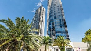 Two high-rise buildings with a clear blue sky and palm trees in the foreground. - Sealuxe Seaview Suites - Central Surfers Paradise (Surfers Paradise)