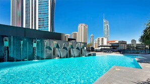 A swimming pool with a cityscape in the background, including high-rise buildings and a distinctive skyscraper. - Sealuxe Seaview Suites - Central Surfers Paradise (Surfers Paradise)