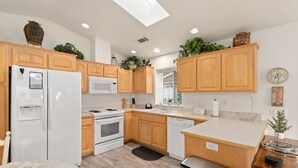 A modern kitchen with wooden cabinets, a white refrigerator, a microwave, an oven, a dishwasher, and a skylight. - COMFY-COZY, Quiet, EV car CHARGER, GARAGE, Recliner  (Grants Pass)