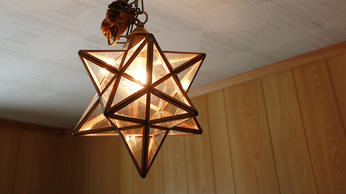 Una lámpara colgante con forma de estrella y una luz cálida.