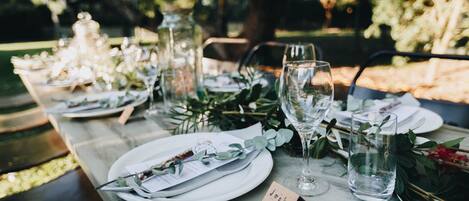 A table set with white plates, clear glasses, and a small card with a name.