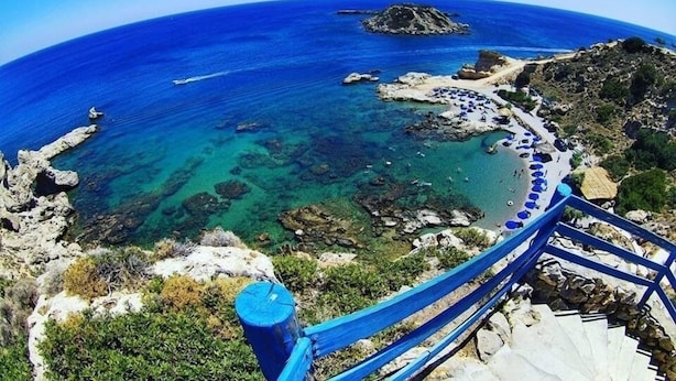 A coastal area with clear blue waters, rocky terrain, and a staircase leading down to the beach. - Grande Blue Suites with private bay (Rhodes)