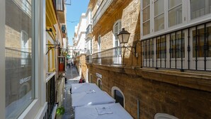 Una calle estrecha con mesas blancas cubiertas con manteles blancos, que sugiere una zona de comedor.