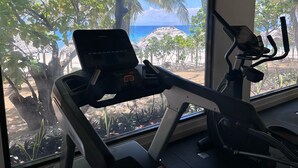 A gym with a stationary bike and an elliptical machine, both with digital displays.