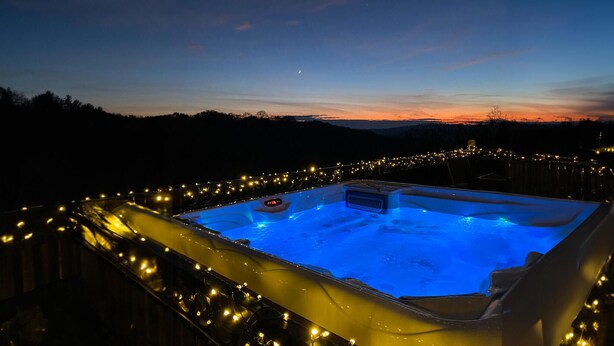 A hot tub surrounded by string lights, set against a twilight sky. - Lovely home in Sv.Martin na Muri with sauna (Sv.Martin na Muri)