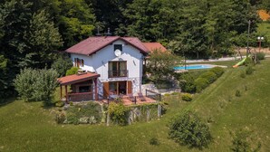 A two-story house with a red roof, a balcony, and a swimming pool in the background. - Lovely home in Sv.Martin na Muri with sauna (Sv.Martin na Muri)