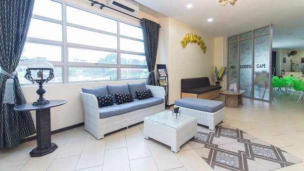 A modern hotel lobby with a sofa, coffee table, and a glass partition with 'NED EXPRESS CAFE' signage. - 328 Apple Hotel Shah Alam (Shah Alam)