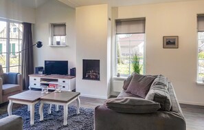 Relax in this cozy living space with a comfortable sofa, flat-screen TV, and fireplace.