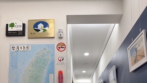 Un couloir avec une carte, des panneaux d’accueil et un extincteur.