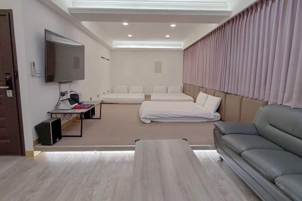 Une chambre d’hôtel moderne équipée d’une télévision à écran plat, d’un canapé, d’un lit et d’une petite table.
