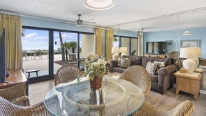 A spacious living room with a glass table, wicker furniture, a sofa set, and a view of the outdoors. - 112- Fabulous BEACH FRONT condo. Destin Beach Club (Destin)