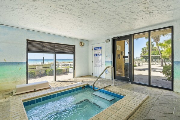 A spa area with a hot tub, a view of the beach, and a sign indicating no diving.