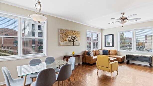 Un salón amplio con una mesa de comedor de cristal, un sofá de cuero y un sillón amarillo.