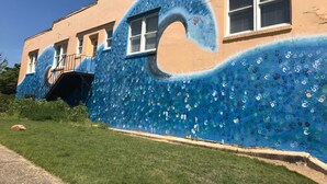 Un edificio con un mural de olas que incluye huellas de manos.
