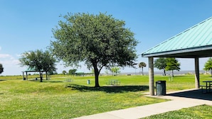 A park with picnic tables, a covered pavilion, and a walking path.