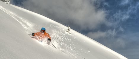 A snowy slope with a skier in motion.