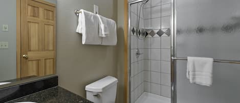 Een badkamer met toilet, wastafel en douche.