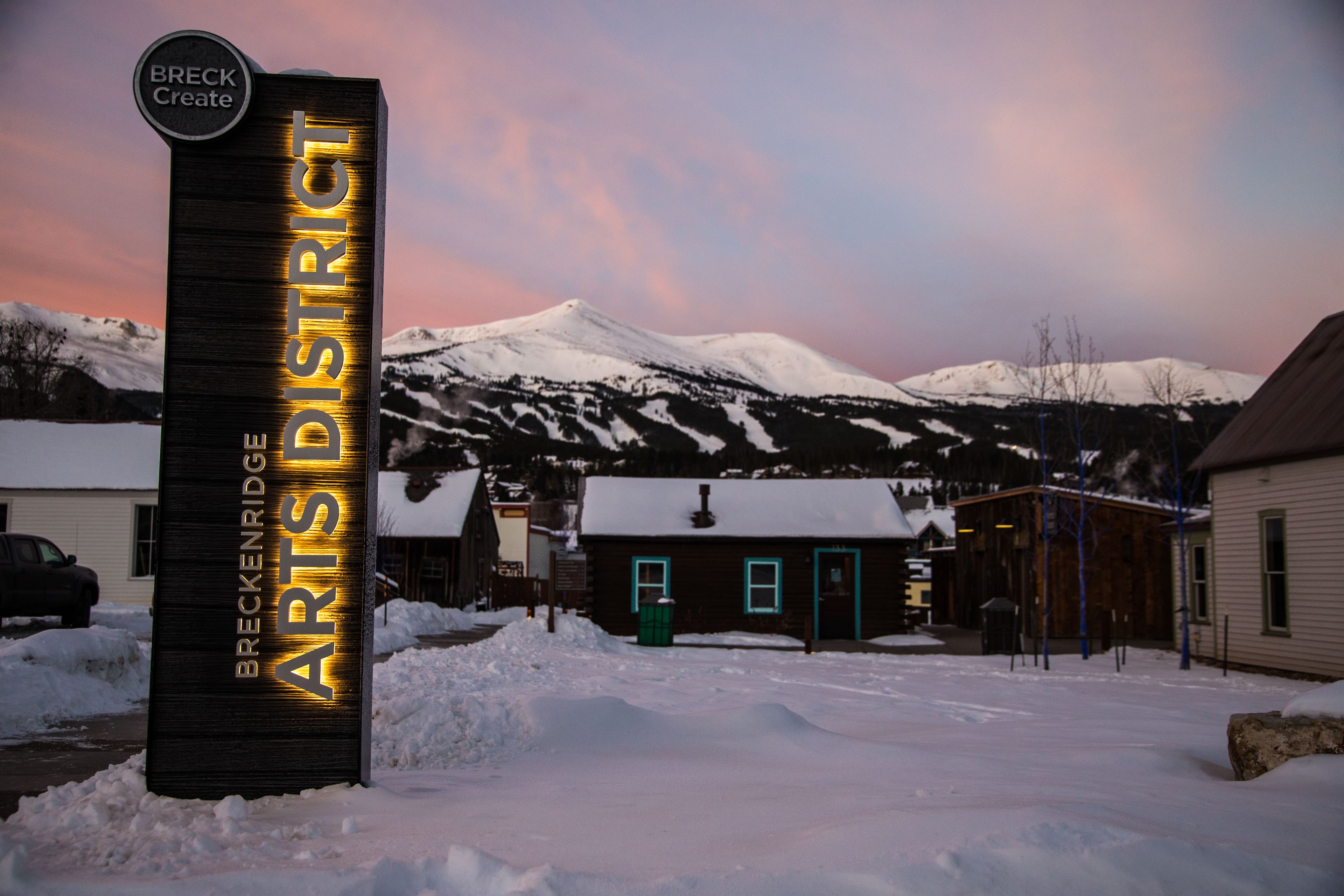 Un panneau indiquant le quartier des arts de Breckenridge, avec une montagne enneigée en arrière-plan.