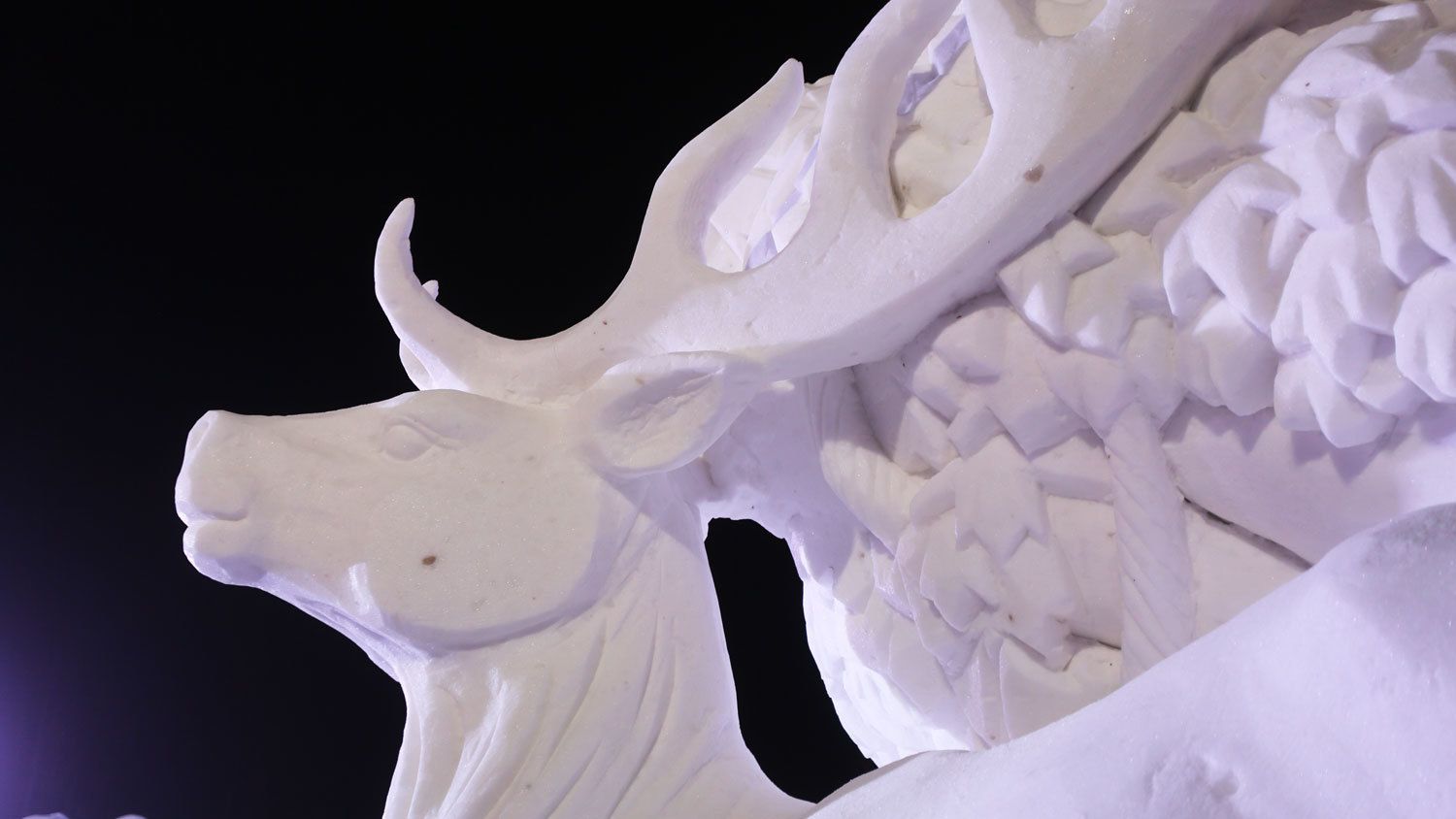Escultura detallada de nieve con la cabeza y los cuernos de un toro.