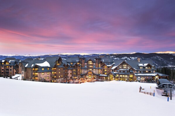 A large lodge with multiple floors and a snow-covered landscape in the background.