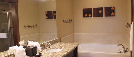 A bathroom with two sinks, a large mirror, and a bathtub.